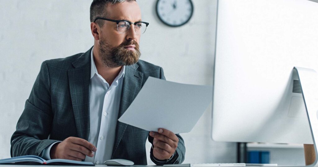 Man looking at fax and file in hand