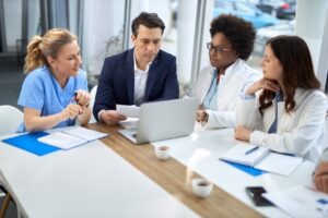 Health system administrators meeting to review fax compliance across facilities
